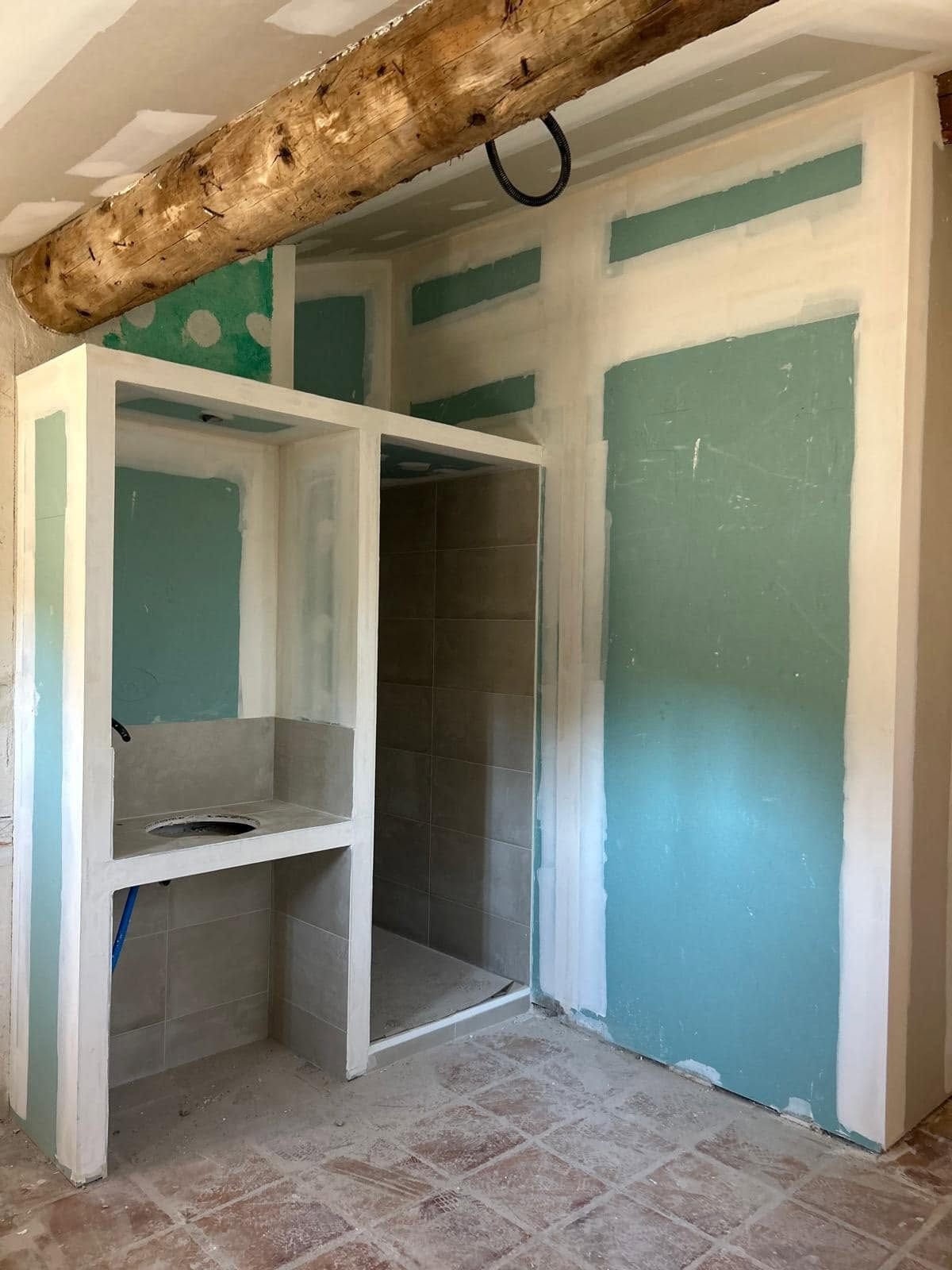 La salle d’eau terminée, douche et vasque en plaques sous la poutre — rénovation d’une grange à Fitou, plaquiste ALVIT PLAQUISTE